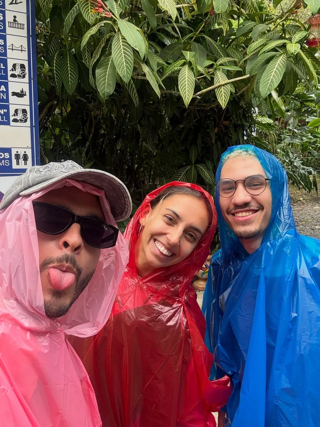 Friends in pink, red and blue rain ponchos, Baños